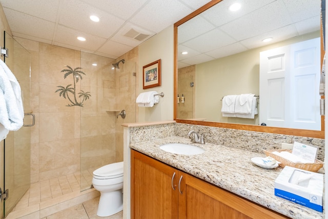 bathroom with tile patterned flooring, a shower with door, vanity, and toilet