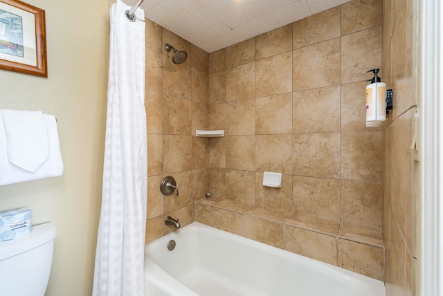 bathroom with shower / bath combo with shower curtain, toilet, and a textured ceiling