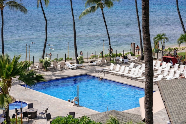 view of pool with a water view and a patio