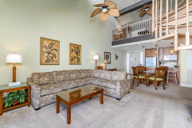 living room featuring ceiling fan, light carpet, beam ceiling, and high vaulted ceiling