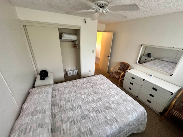 carpeted bedroom with ceiling fan, a closet, and a textured ceiling