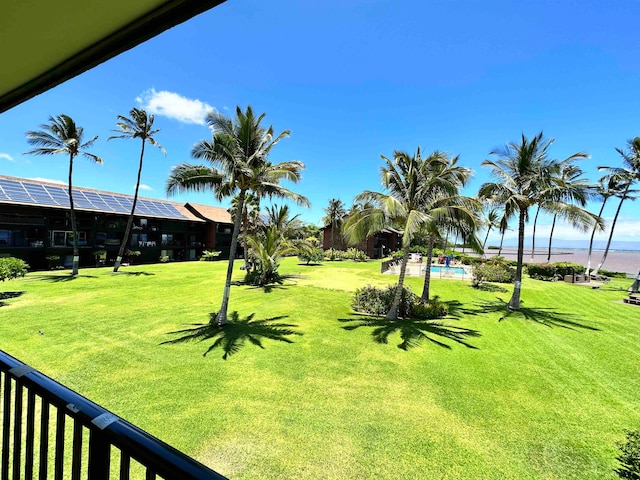 view of yard with a swimming pool and a water view