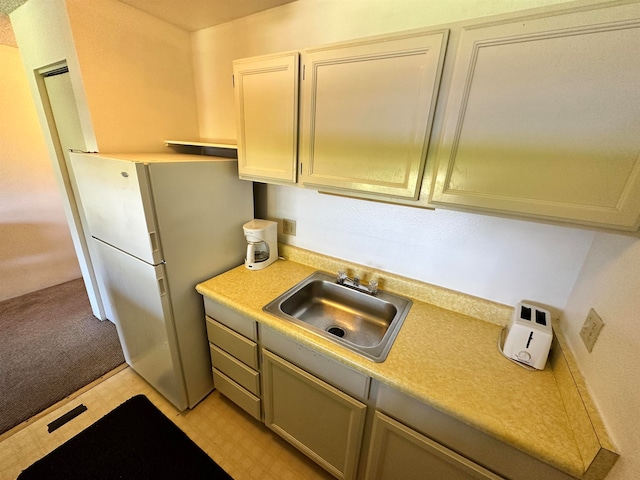 kitchen with sink, white fridge, and light tile patterned floors