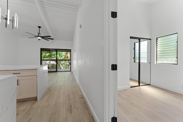 hall featuring beamed ceiling, baseboards, high vaulted ceiling, and light wood-style flooring