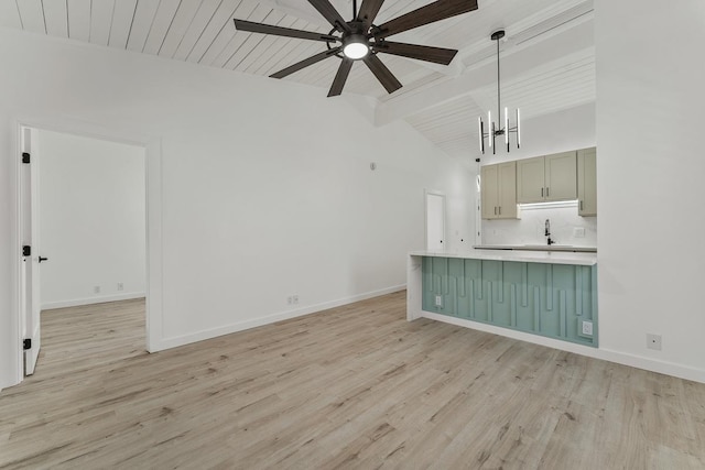 unfurnished living room featuring light wood-style flooring, lofted ceiling with beams, baseboards, and a sink