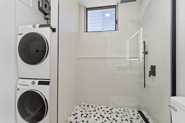 clothes washing area with laundry area and stacked washing maching and dryer