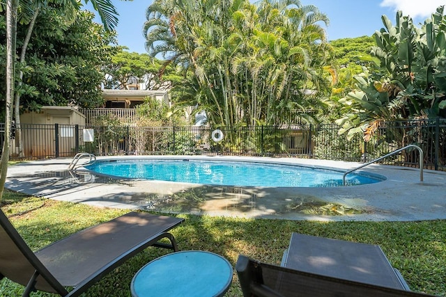 community pool with a patio area and fence