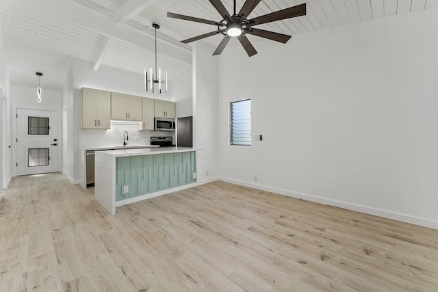 kitchen with decorative light fixtures, light wood-type flooring, light countertops, beam ceiling, and stainless steel appliances