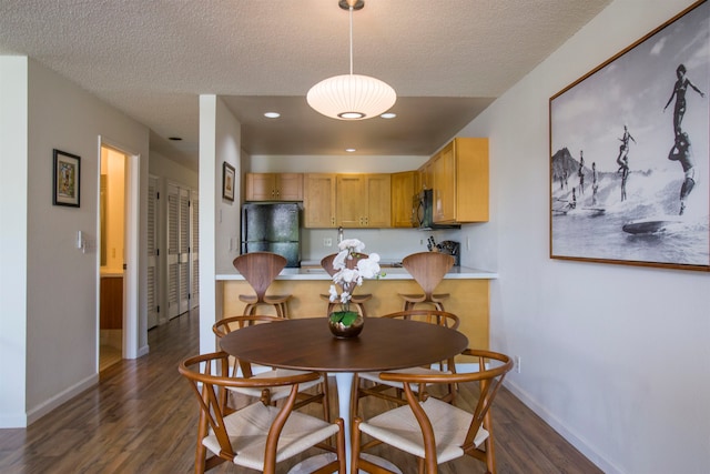 dining space featuring a textured ceiling and dark wood-type flooring