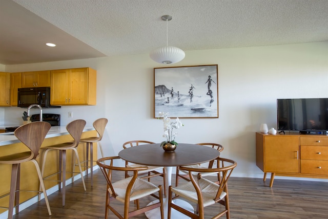 dining room featuring a textured ceiling and dark wood-type flooring