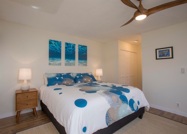 bedroom with a closet, hardwood / wood-style floors, and ceiling fan