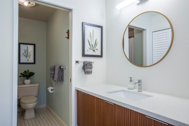 bathroom with vanity, toilet, and tile flooring