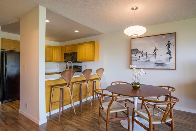 dining space featuring dark hardwood / wood-style flooring and a textured ceiling