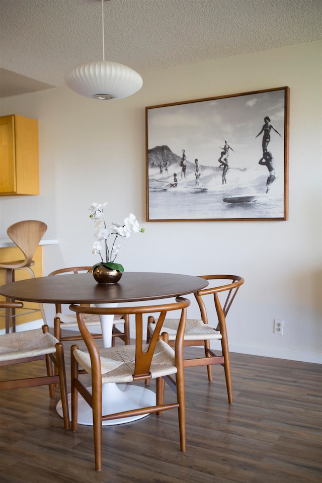 dining area with dark hardwood / wood-style flooring and a textured ceiling