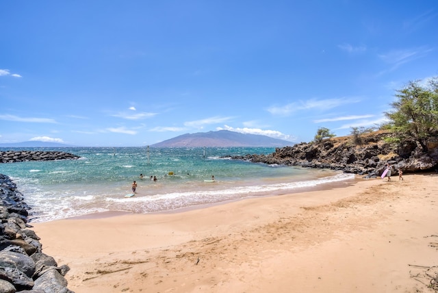 water view with a mountain view and a view of the beach