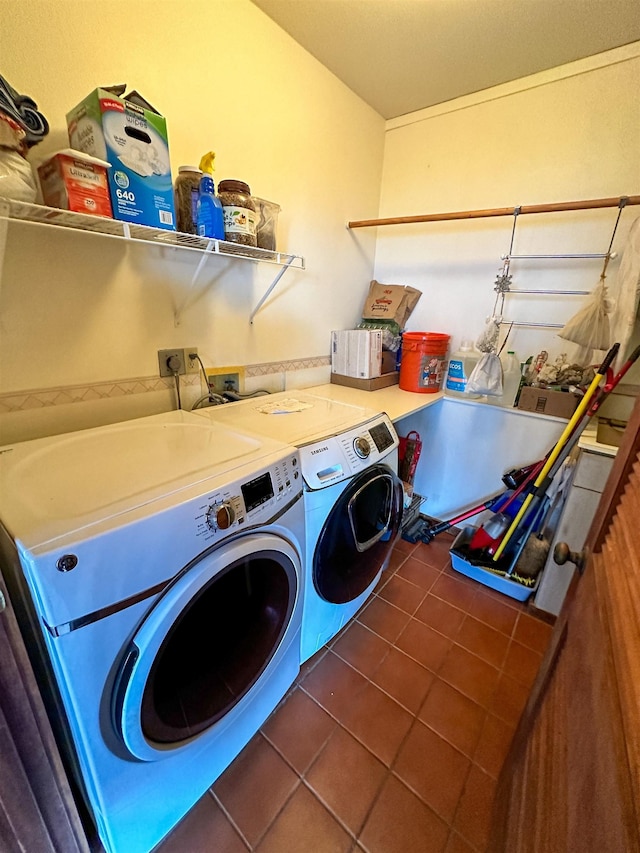 laundry room with dark tile patterned floors and washer and dryer