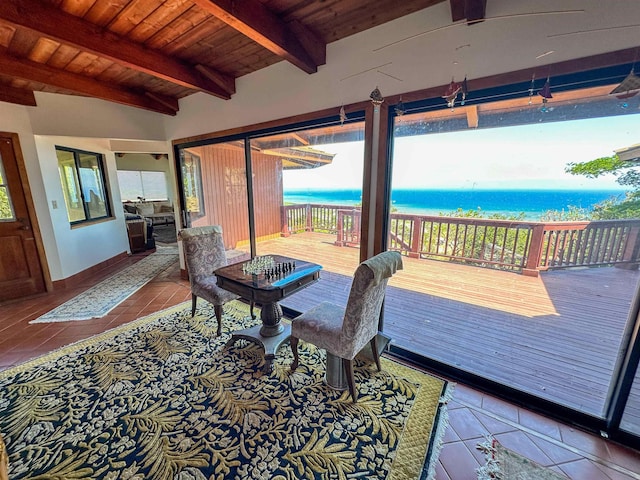 interior space with a view of the beach, lofted ceiling with beams, light tile patterned flooring, wood ceiling, and a water view