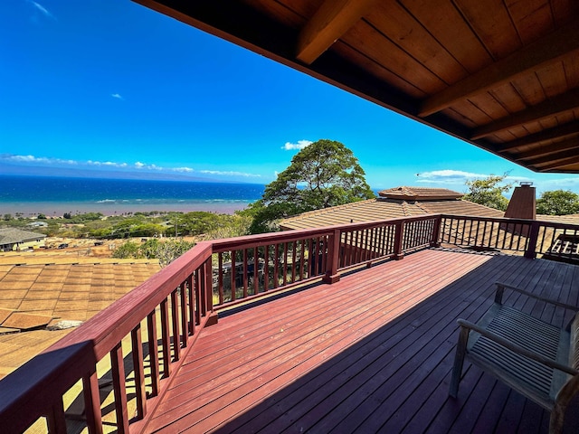 wooden deck featuring a water view and a view of the beach