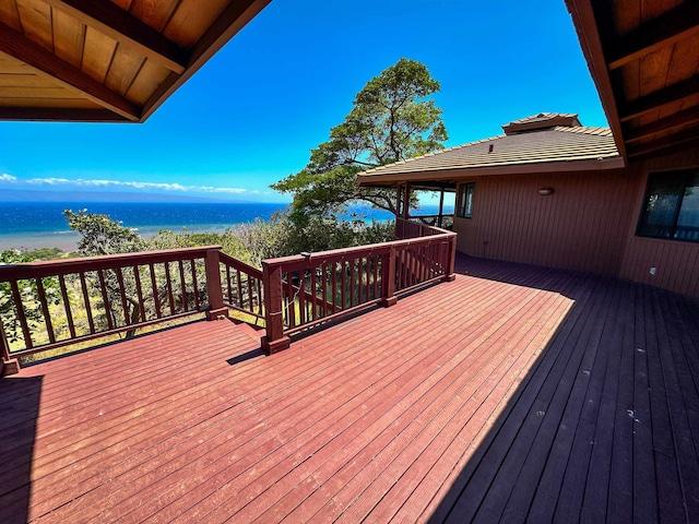 deck with a view of the beach and a water view