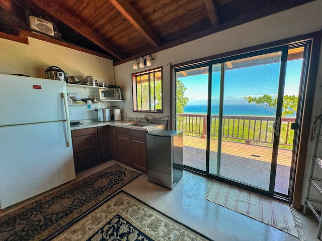 kitchen featuring appliances with stainless steel finishes, wood ceiling, sink, lofted ceiling with beams, and a water view