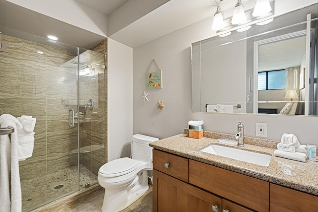 bathroom featuring toilet, a stall shower, and vanity