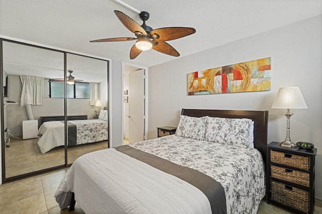 bedroom with a closet, light tile patterned flooring, and ceiling fan