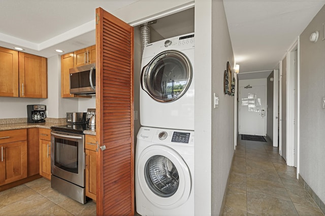 laundry room featuring laundry area, stacked washer / drying machine, and recessed lighting