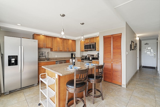 kitchen featuring stainless steel appliances, decorative light fixtures, and brown cabinets