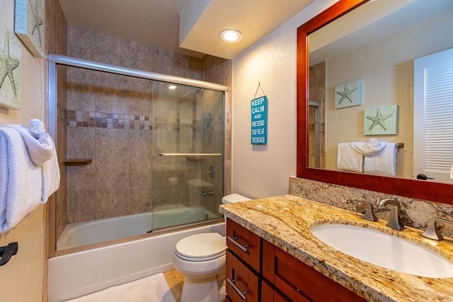 full bathroom featuring bath / shower combo with glass door, a textured ceiling, toilet, vanity, and tile patterned floors