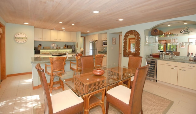 tiled dining area featuring wine cooler, sink, and wooden ceiling