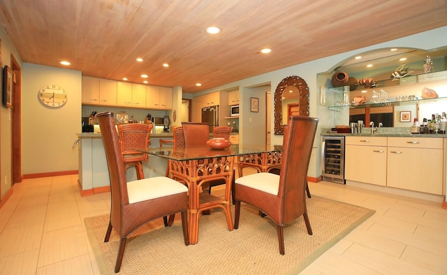 dining area featuring beverage cooler, sink, light tile floors, and wood ceiling