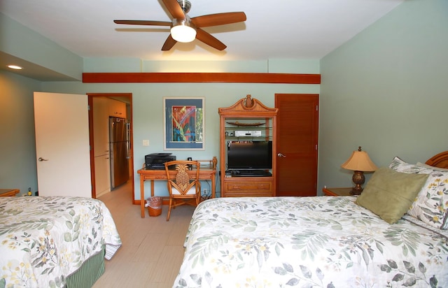 bedroom featuring ceiling fan and stainless steel fridge