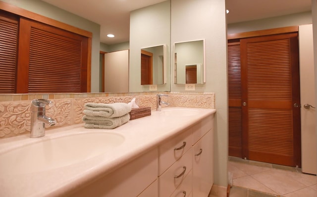 bathroom with dual sinks, oversized vanity, backsplash, and tile flooring