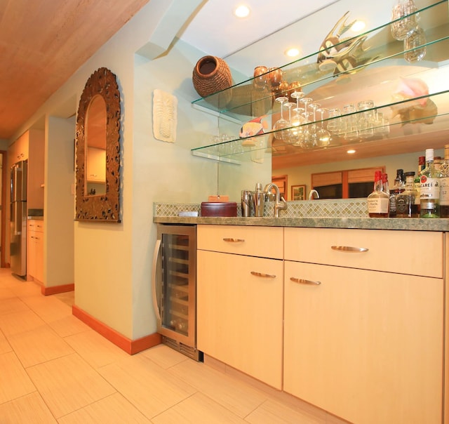 bar featuring beverage cooler, light tile flooring, stainless steel fridge, and stone countertops