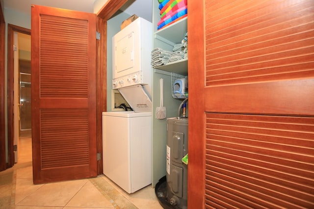 clothes washing area with water heater, washer hookup, tile floors, and stacked washer / drying machine