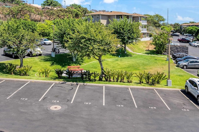 view of vehicle parking with a lawn