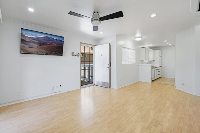 unfurnished living room with light hardwood / wood-style floors, ornamental molding, and ceiling fan