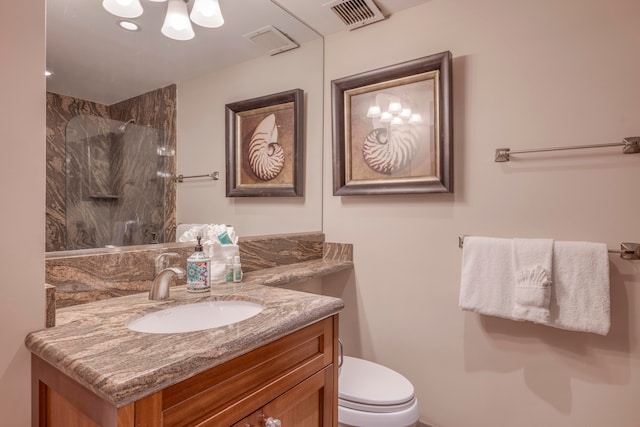 bathroom featuring a shower, vanity, and toilet