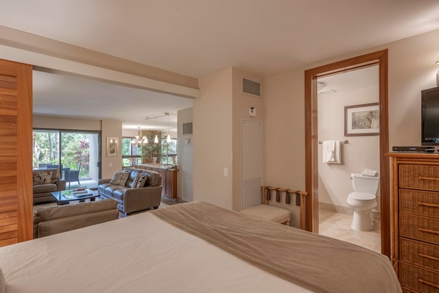 bedroom featuring connected bathroom and a chandelier