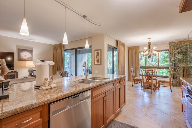 kitchen featuring light stone countertops, dishwasher, pendant lighting, and plenty of natural light