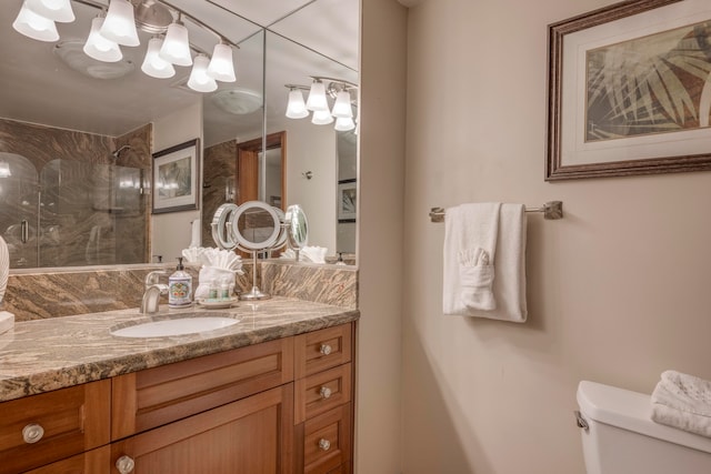 bathroom featuring a tile shower, vanity, and toilet