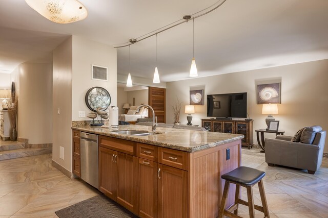 kitchen featuring sink, a center island with sink, decorative light fixtures, light stone countertops, and stainless steel dishwasher