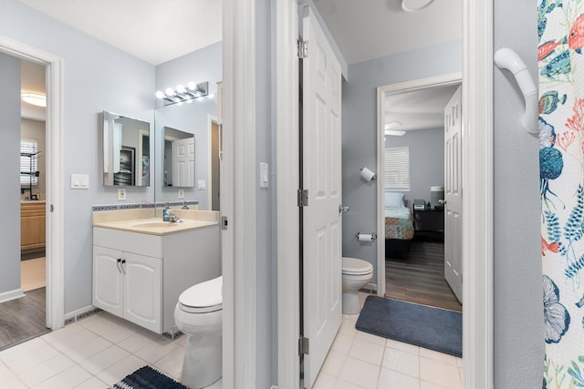 bathroom with hardwood / wood-style floors, vanity, ceiling fan, and toilet