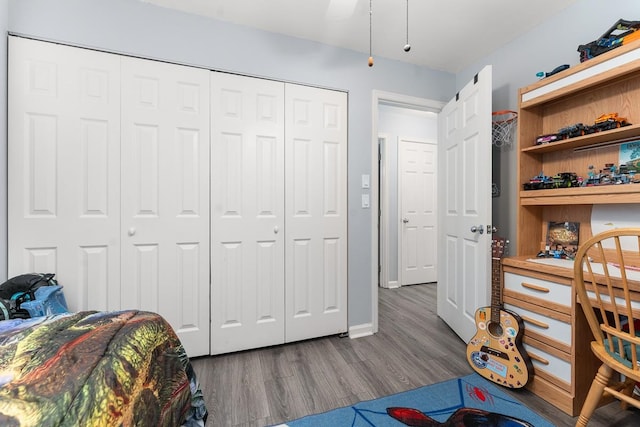 bedroom with ceiling fan, wood-type flooring, and a closet