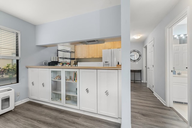 kitchen with light brown cabinets, dark hardwood / wood-style flooring, and white fridge with ice dispenser