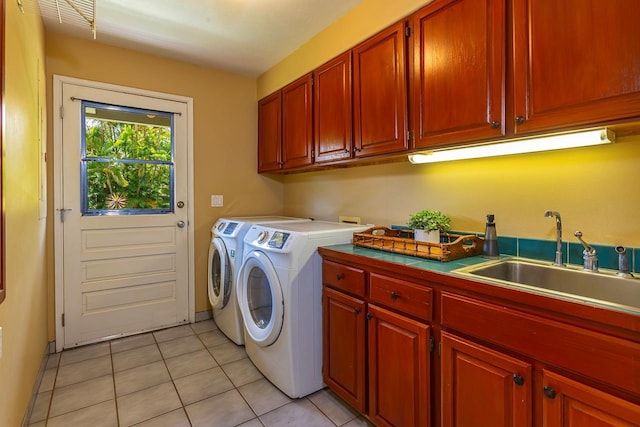 laundry room with washer and dryer, light tile patterned flooring, cabinets, and sink