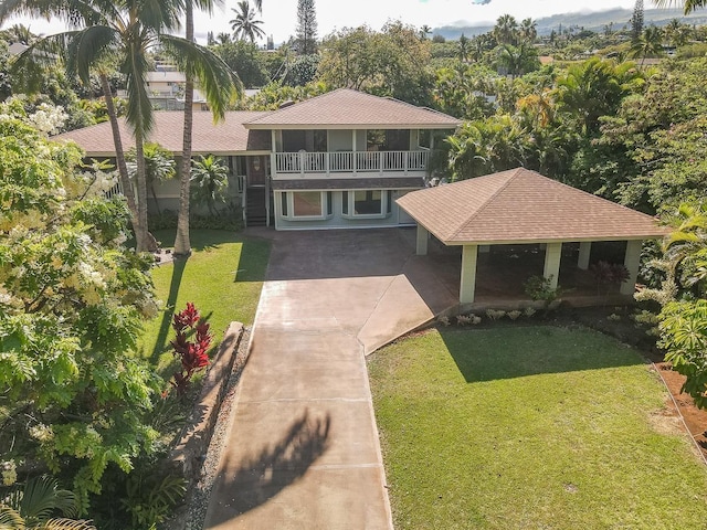 view of front of house with a front yard and a balcony