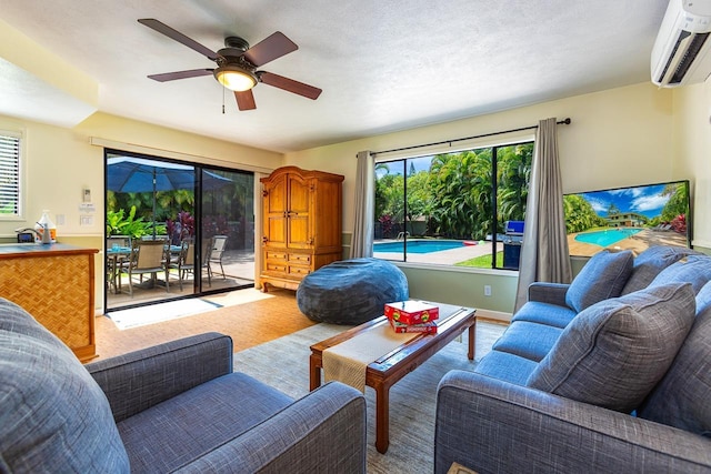 living room with ceiling fan, an AC wall unit, and a textured ceiling