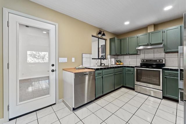 kitchen featuring green cabinets, sink, appliances with stainless steel finishes, tasteful backsplash, and light tile patterned flooring