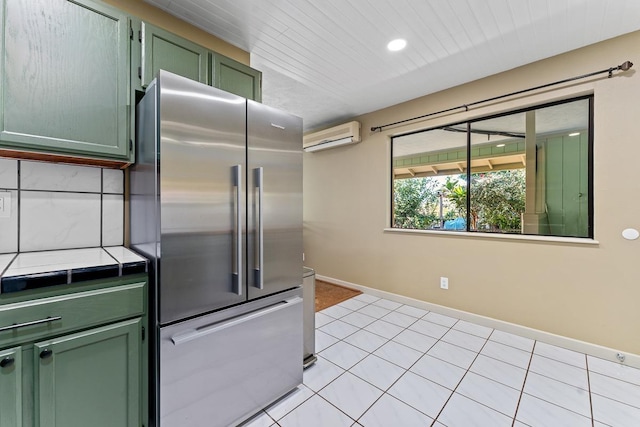 kitchen featuring an AC wall unit, green cabinetry, light tile patterned floors, high quality fridge, and tile counters